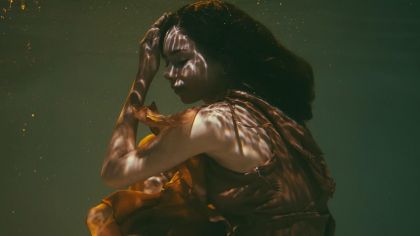 joven sumergida el agua con rostro triste